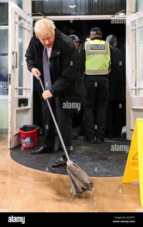 britains-prime-minister-boris-johnson-mops-the-floor-to-help-with-the-clean-up-at-an-opticians-during-a-visit-to-the-flood-hit-town-of-matlock-derbyshire-britain-november-8-2019-picture-taken-november-8-2019-danny-lawsonpool-via-reuters-2CJ7PYT.jpg